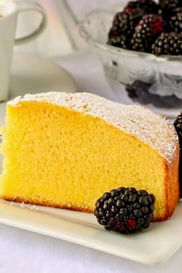 Close up photo of a single slice of condensed milk cake on a white plate