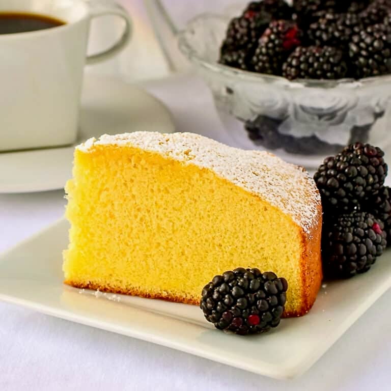 Close up photo of a single slice of condensed milk cake on a white plate