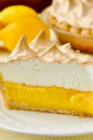 Homemade Lemon Meringue Pie photo of one slice on a white plate.