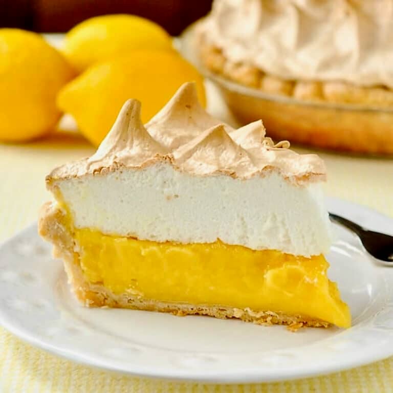 Homemade Lemon Meringue Pie photo of one slice on a white plate.