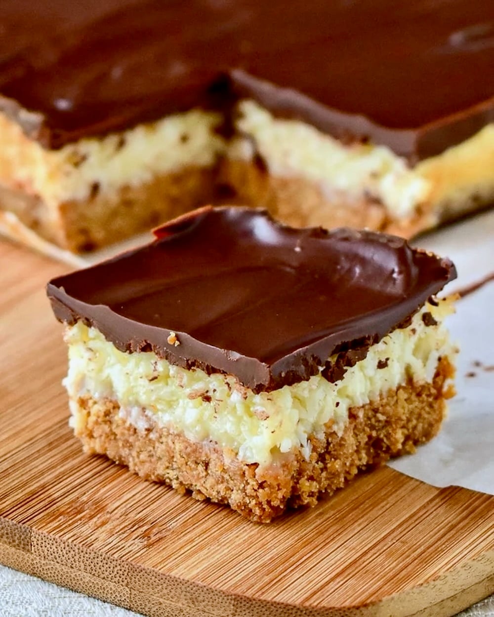 Close up photo of Coconut Dream Bars on a wooden cutting board.