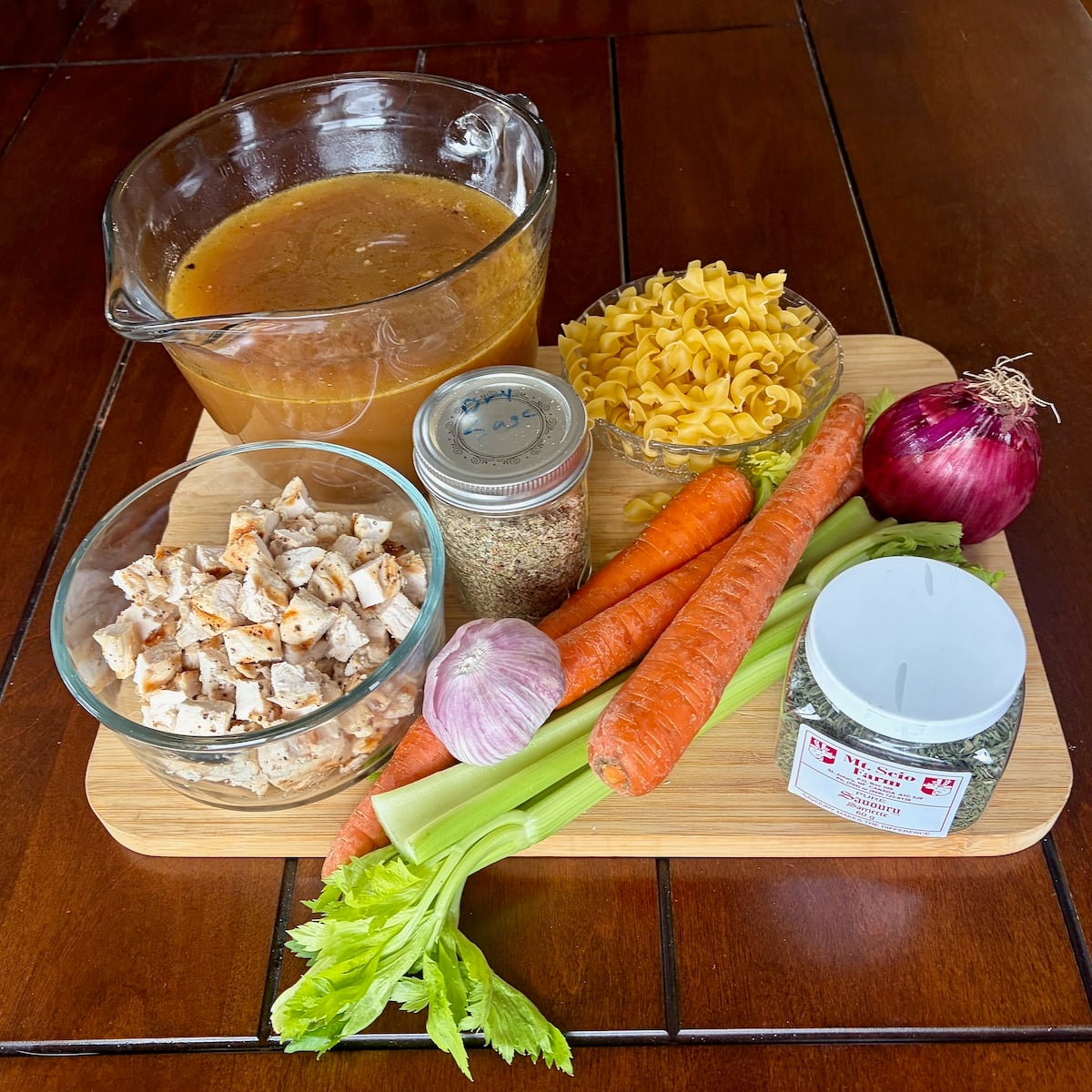 Ingredients for Chicken Noodle Soup on a wooden cutting board