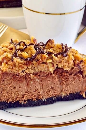 One slice of German Chocolate Cheesecake on a white and gold coffee service for featured image