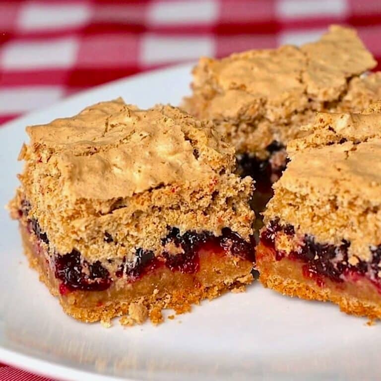 Partridgeberry Coconut Meringue Squares cropped featured image of cut squares on a white plate