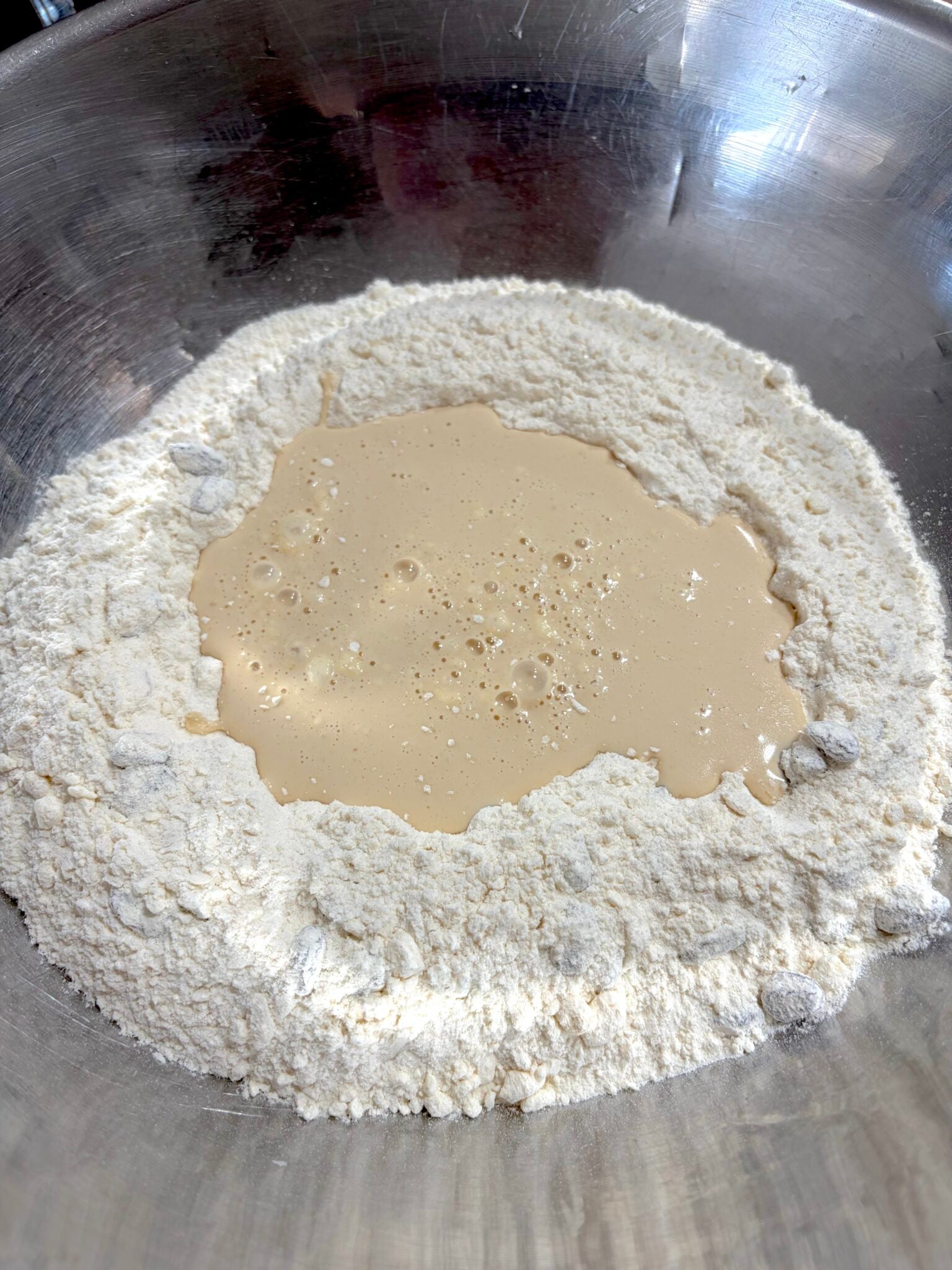 Milk being added to teh dry ingredients.