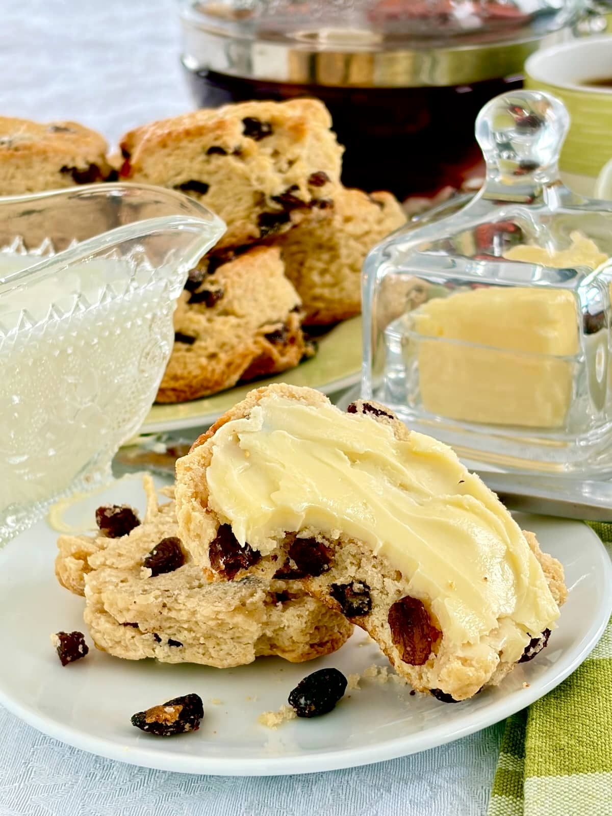 Close up photo of a tea bun split in half and buttered with one bite taken out,