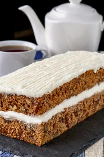 Spanish Bar Cake on a slate serving plate with coffee in the background.