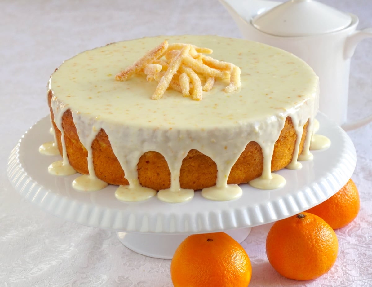 Clementine Cake wide shot photo of completed cake on a white cake pedestal