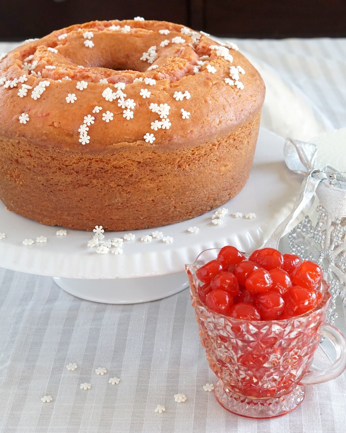 Close up photo of Maraschino Cherry Almond Pound Cake on a white cake stand