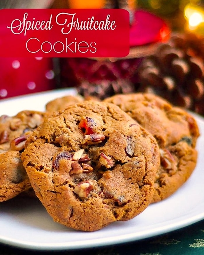 Dark Fruitcake Cookies  photo of cookies on a white plate with Christmas decorations in the background sized for social media