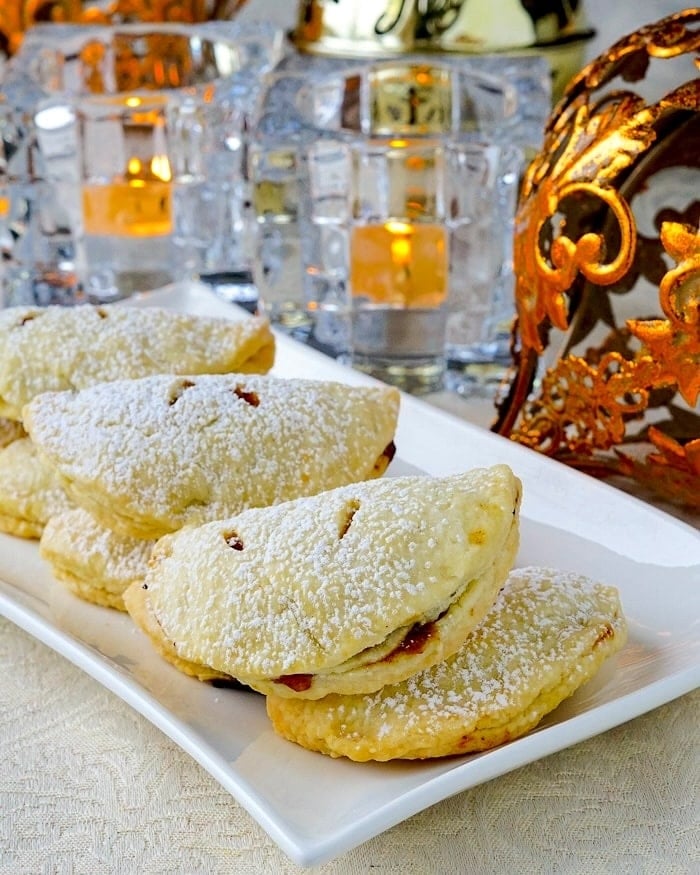 Mini Turnover version of Mince Pies with Clementine and Brandy. photo with decorations in background.