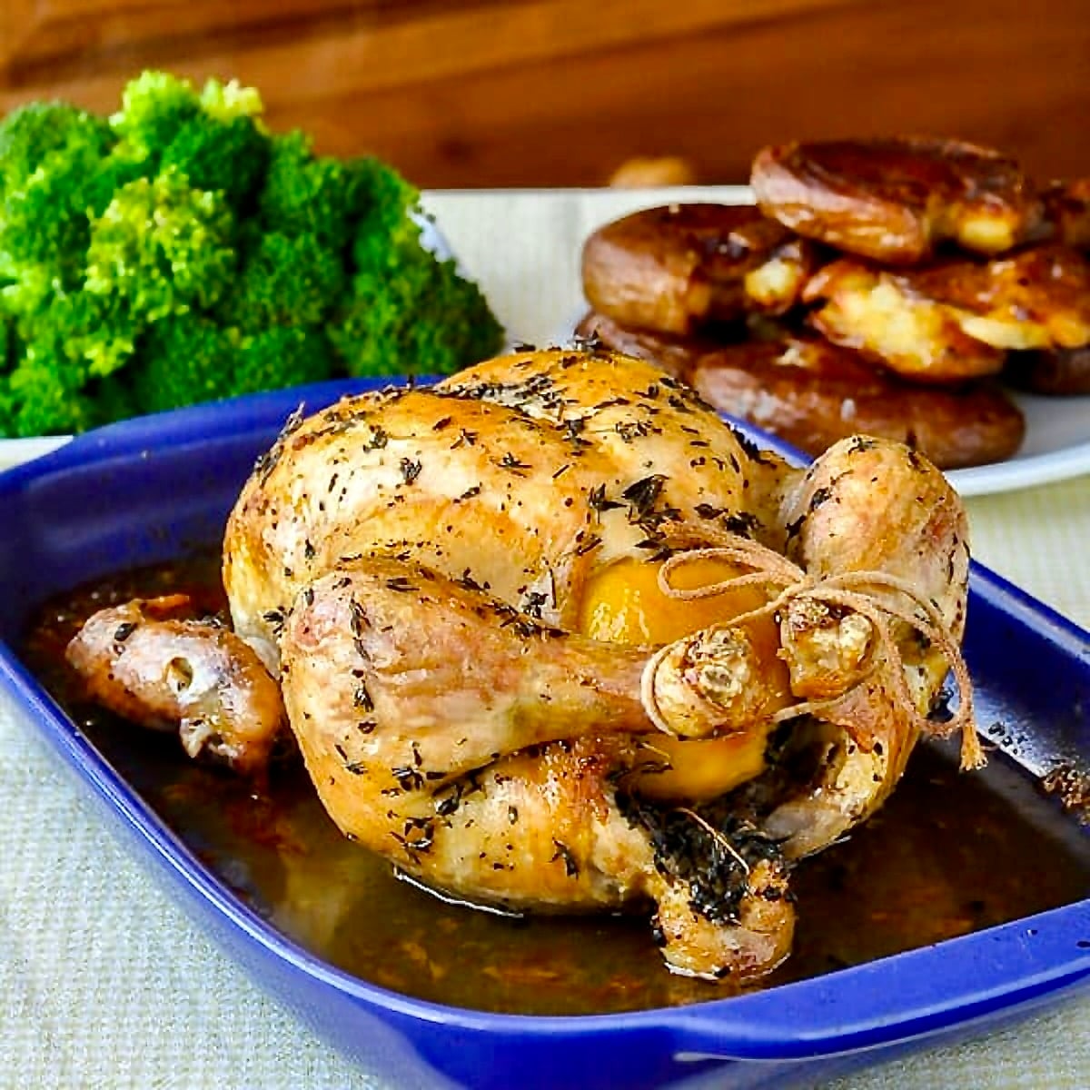 Lemon Thyme Roast Chicken, just out of the oven on a blue ceramic roasting tray for Google featured image.