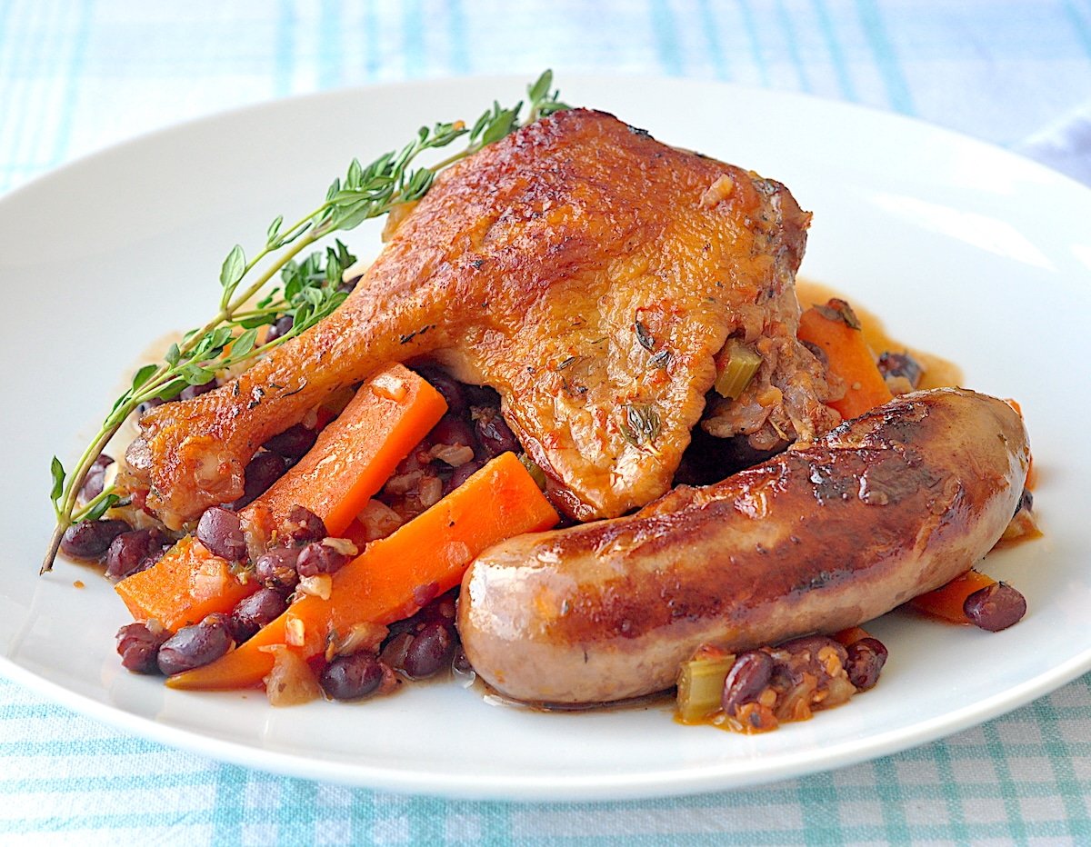 Black Bean, Sausage & Duck Cassoulet wide shot photo on a white plate.