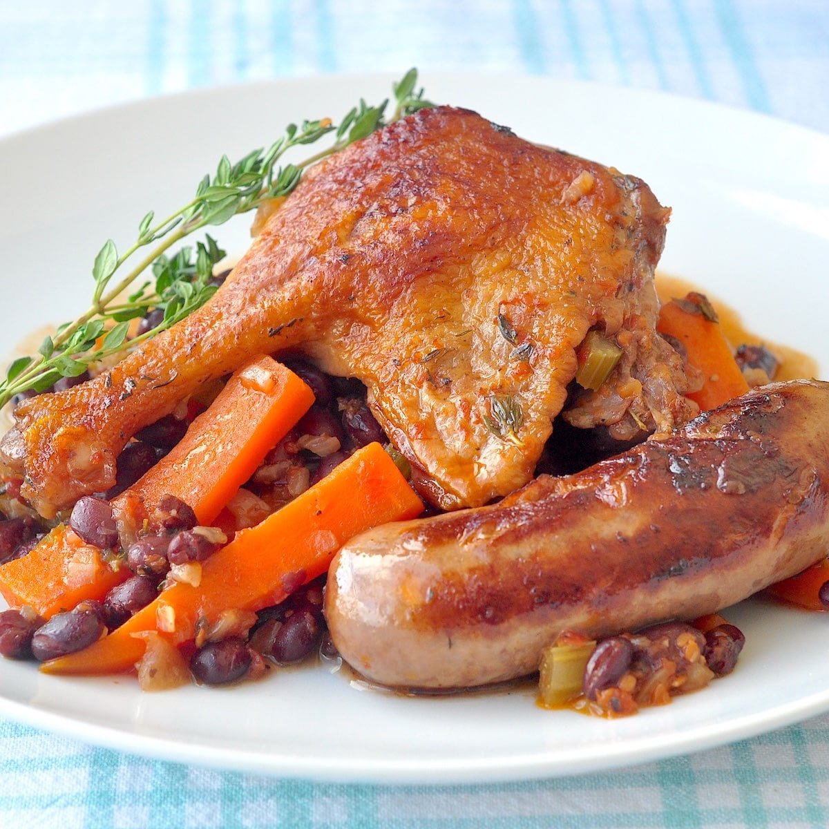 Black Bean, Sausage & Duck Cassoulet close up photo in a white plate.