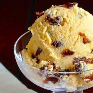 Rum Raisin Ice Cream close up photo of one scoop in a glass dish formatted as featured Google image.