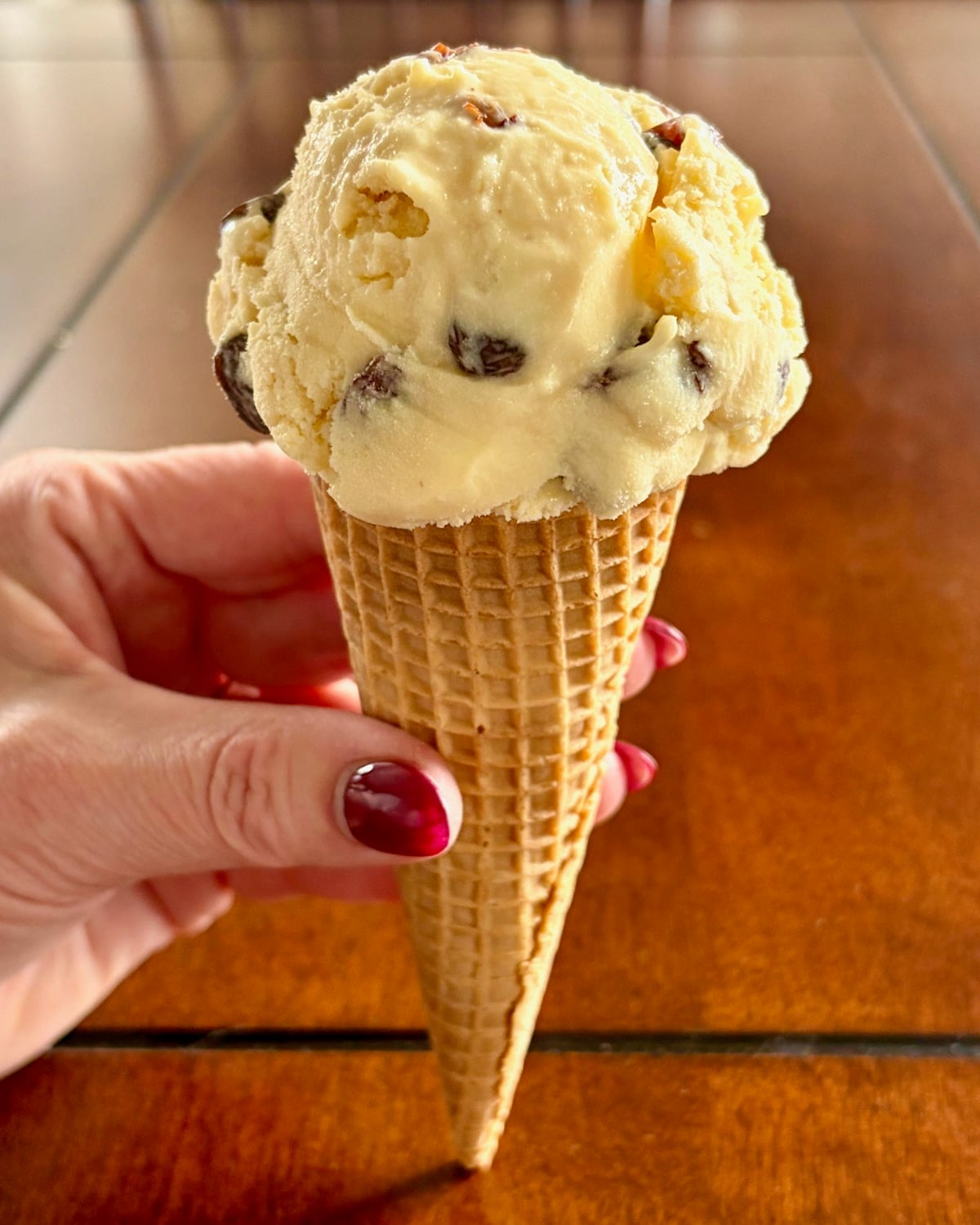 Rum Raisin Ice Cream pictured in a sugar cone.
