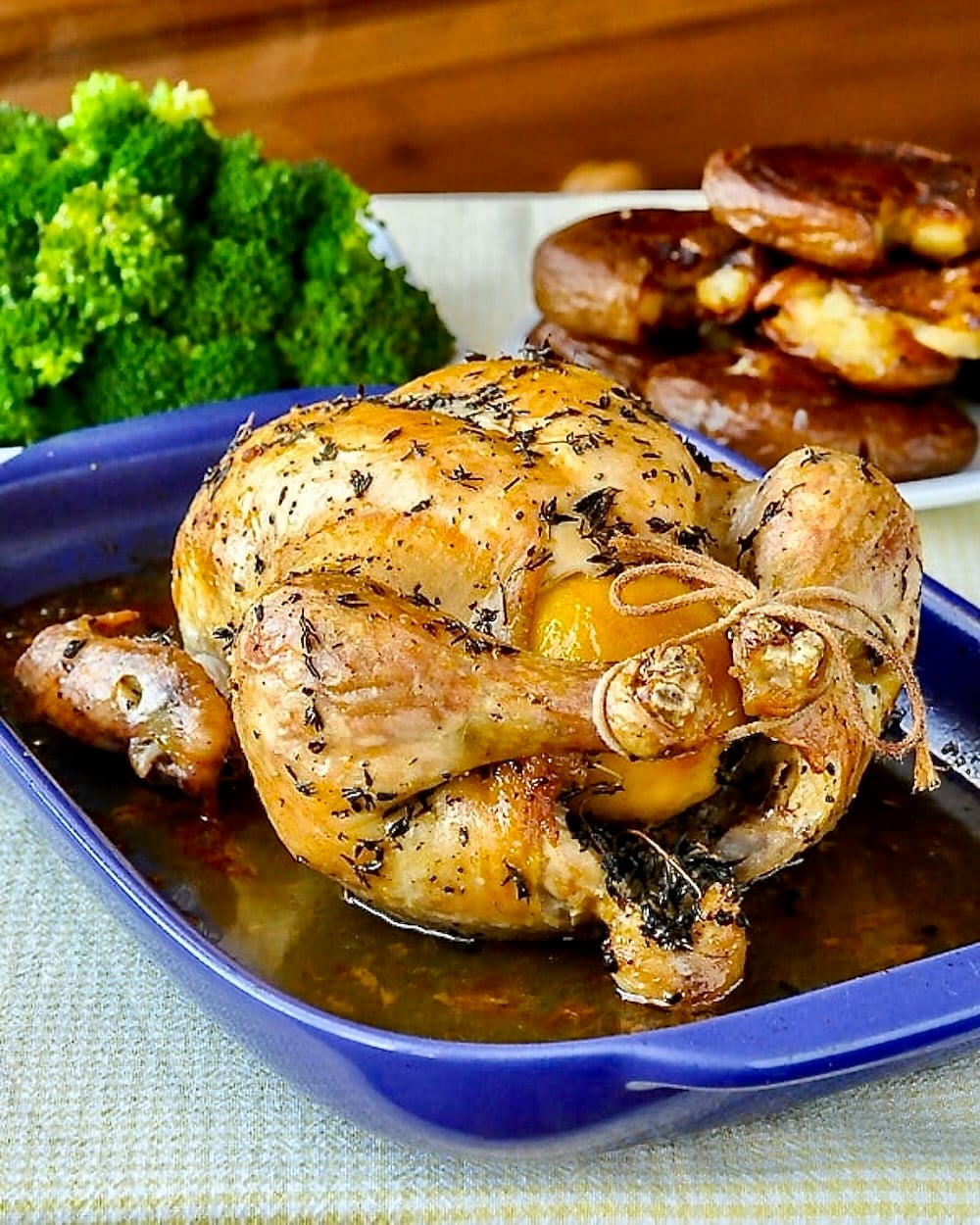 Lemon Thyme Roast Chicken, just out of the oven on a blue ceramic roasting tray