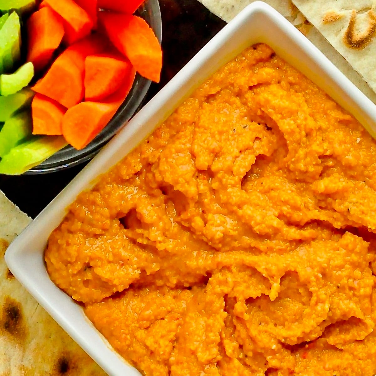 Roasted Red Pepper Hummus close up photo of hummus in a white bowl