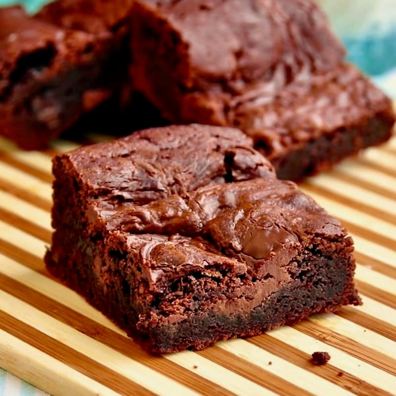 Nutella Swirl Brownies photo of one  brownir=e on a wooden cutting board.