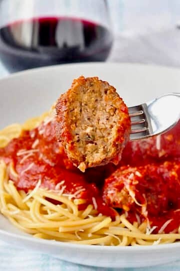 The Best Spaghetti and Meatballs close up photo of a meatball with a bite taken out.