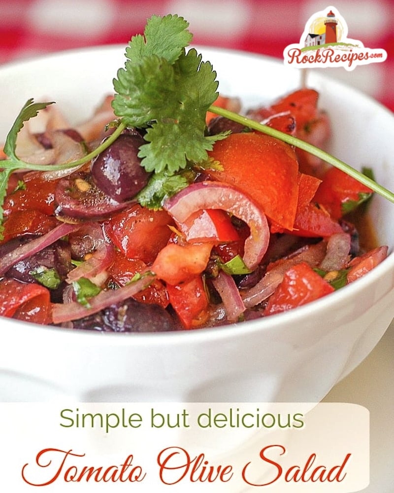 Tomato Olive Salad photo of one serving in a white bowl with title text added for social media posts.