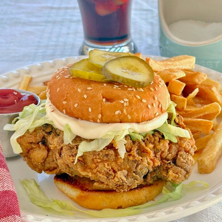 Copycat Big Mary Chicken Sandwich photo of completed sandwich with french fries in the background.