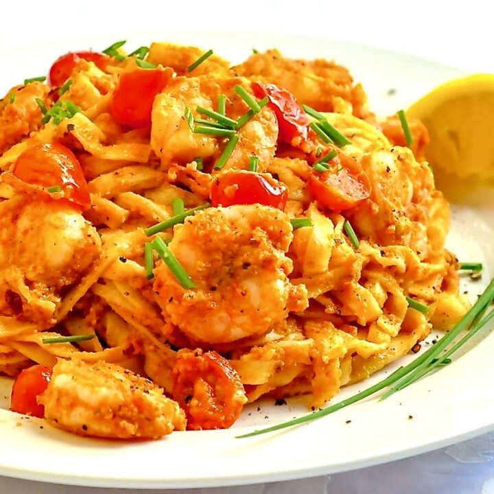 Almond Sun Dried Tomato Pesto Linguine photo of single serving ion white plate with lemon and chive garnish