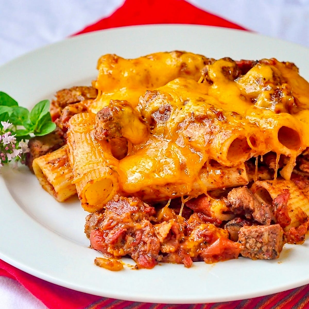 Cheesy Steak & Bacon Baked Pasta close up image of single serving on a white plate