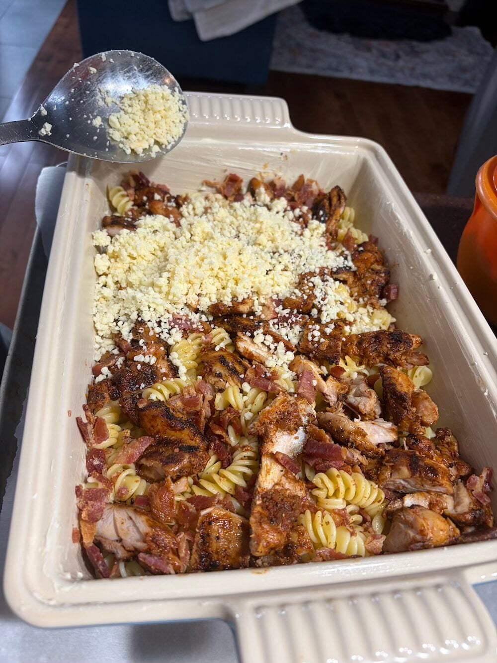 Adding a layer of cheese.