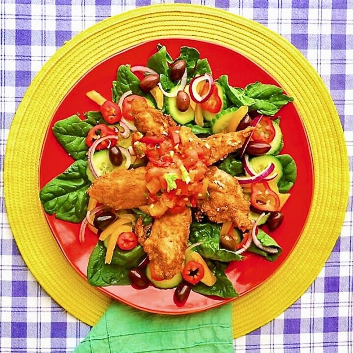 Mexican Spiced Chicken and Lime Salsa Salad pn a red plate on yellow background placemat.