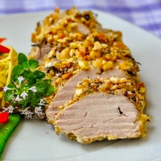 Almond Herb Crusted Pork Tenderloin close up photo of single serving on white plate