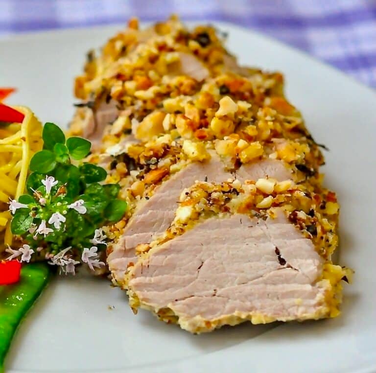 Almond Herb Crusted Pork Tenderloin close up photo of single serving on white plate
