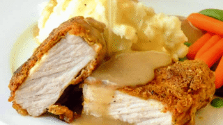 Chicken Fried Pork Chops photo of one serving in a white plate with gravy being poured on