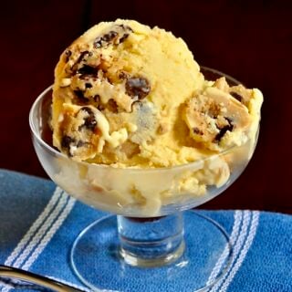 Chocolate Chip Cookie Dough Ice Cream close up photo of one scoop in a clear glass dish.