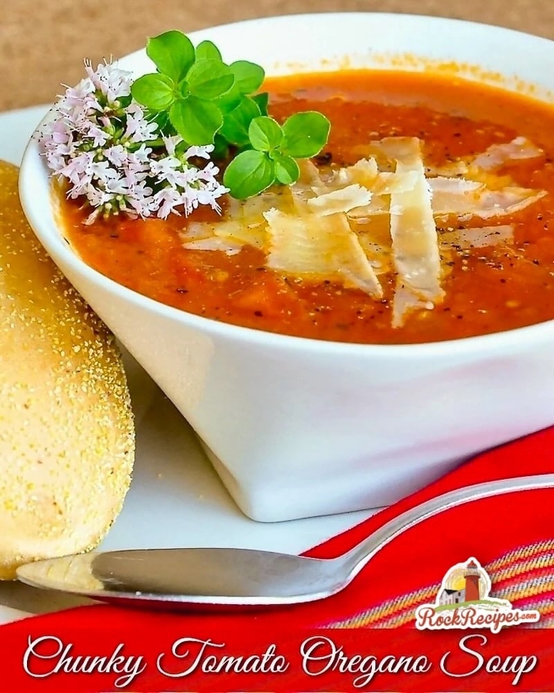 Chunky Tomato Oregano Soup close up photo of a single serving in a white bowl with title text added for Social media posts.