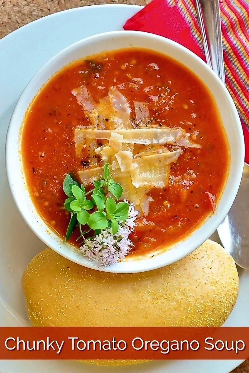 Chunky Tomato Oregano Soup close up photo of a single serving in a white bowl with title text added for Pinterest.