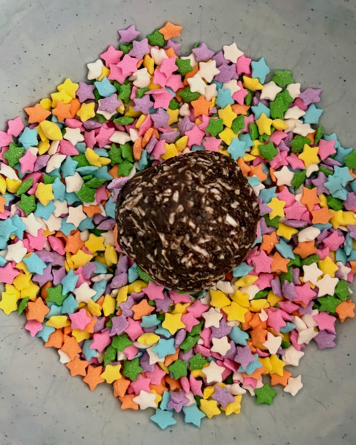 Photo of cookie ball ready to be rolled in sprinkles.