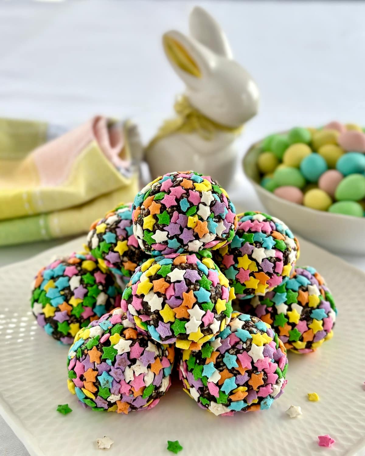 Photo of uncut Easter Bunny Farts stacked on a white plate. with mini eggs in background.