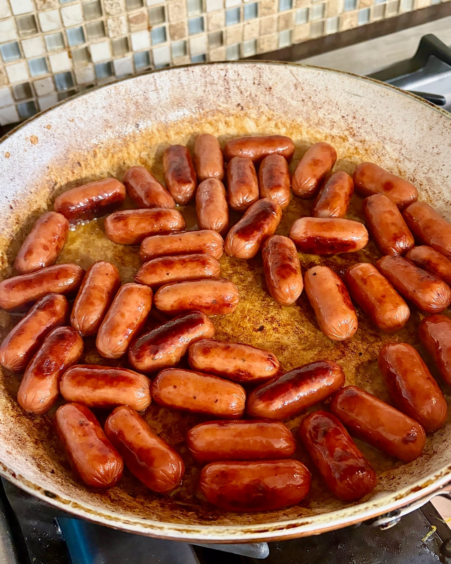 Photo of cocktail franks in a frying pan.