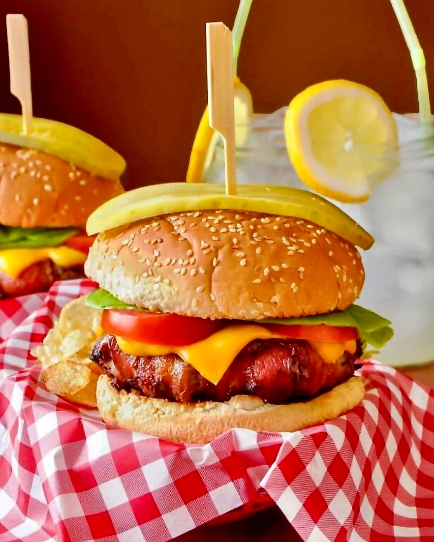 The Ultimate Bacon Wrapped Cheeseburger pictured in a takeout basket