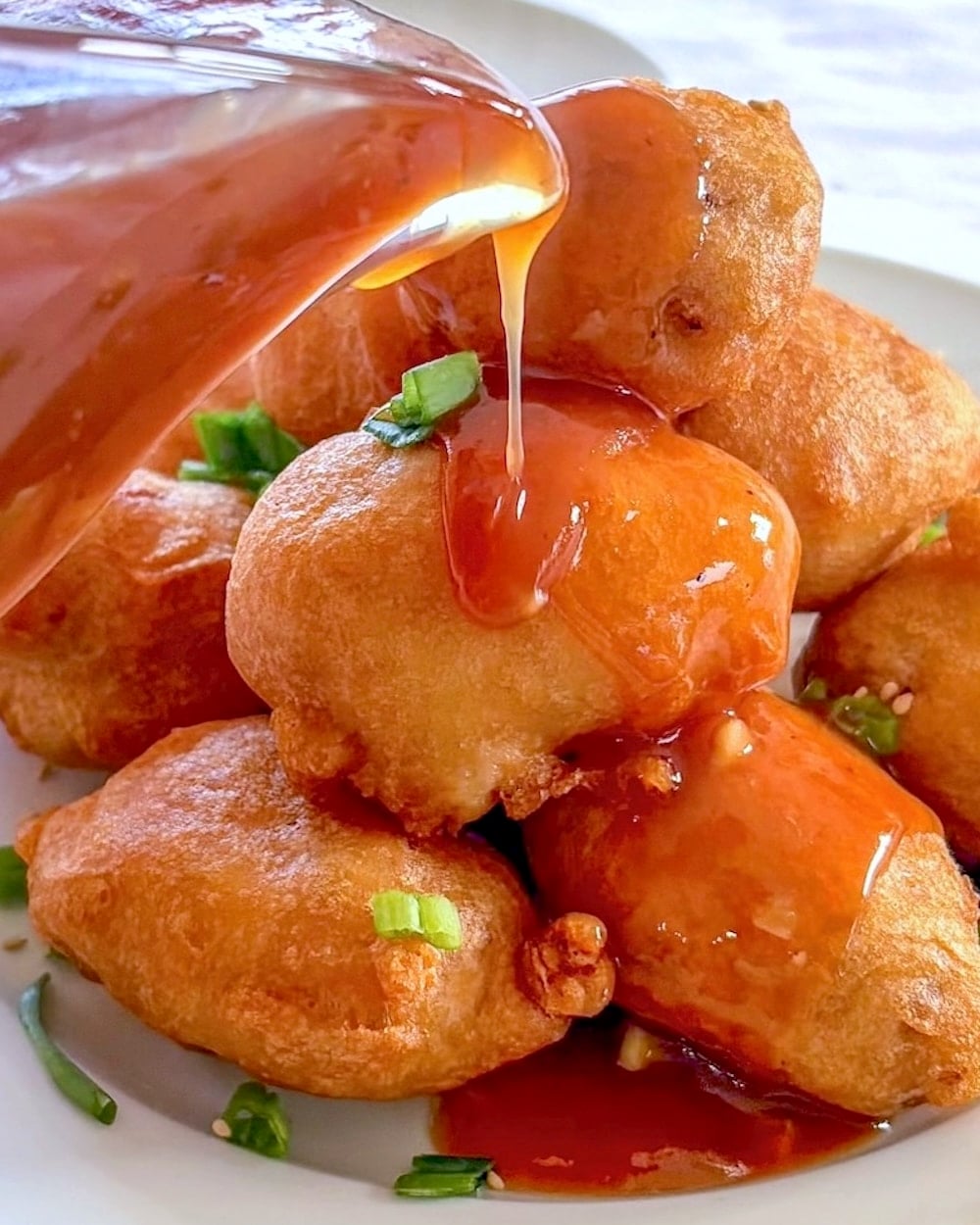 Chinese Chicken Balls with sauce close up photo if pouring sauce