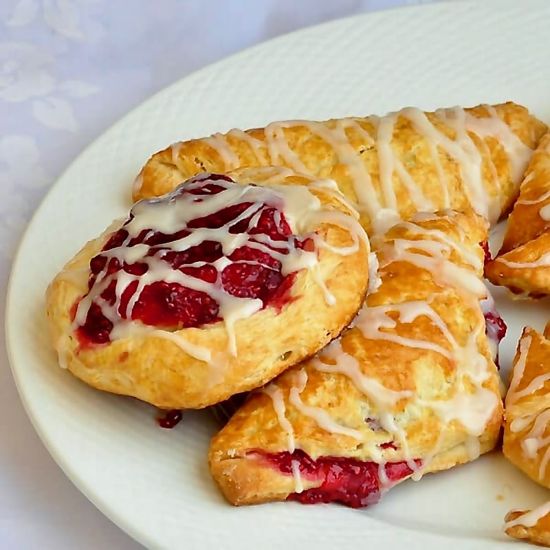 Classic danish and turnovers on a white plate.