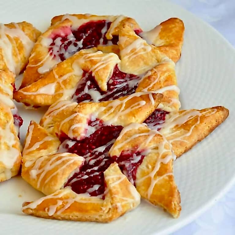 Several pinwheel Danish in a white plate.