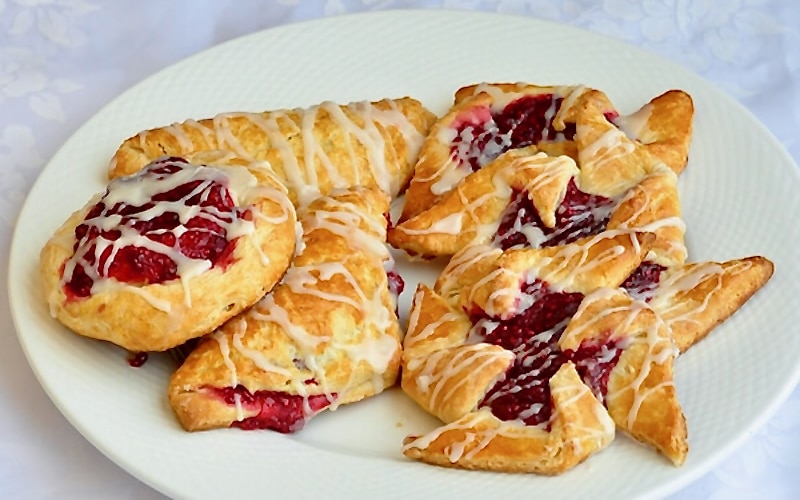 A variety of danish in a white plate.