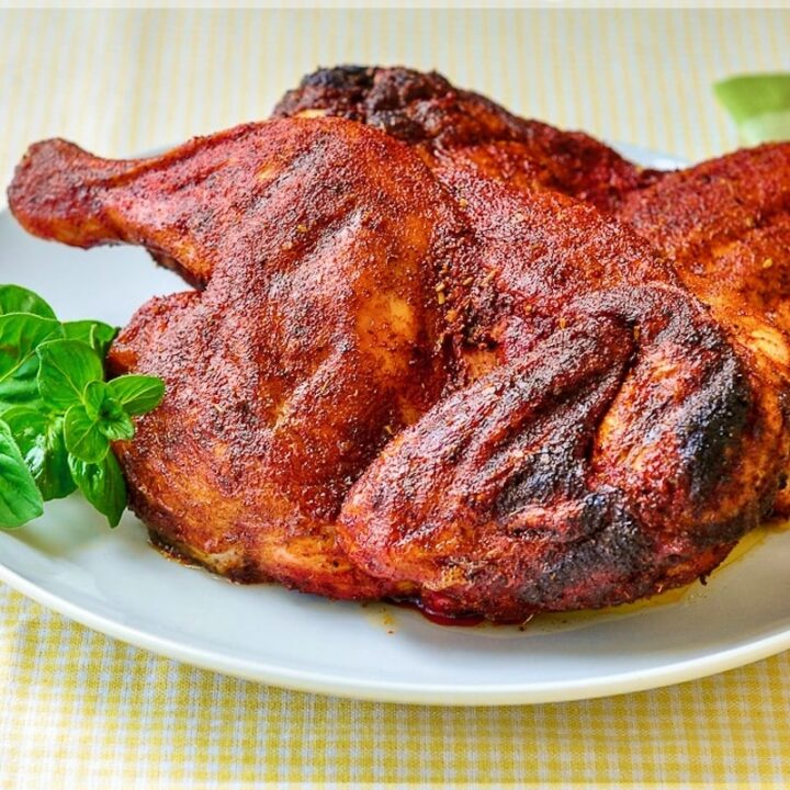 Dry Rubbed Barbecue Chicken. with fresh herbs on a white plate.