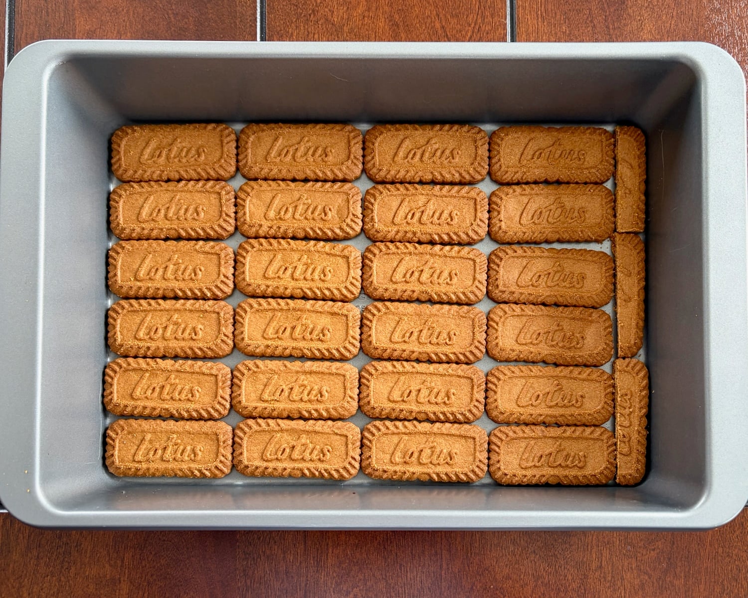 Photo of Lining the bottom of a 9x13 pan with biscoff cookies.