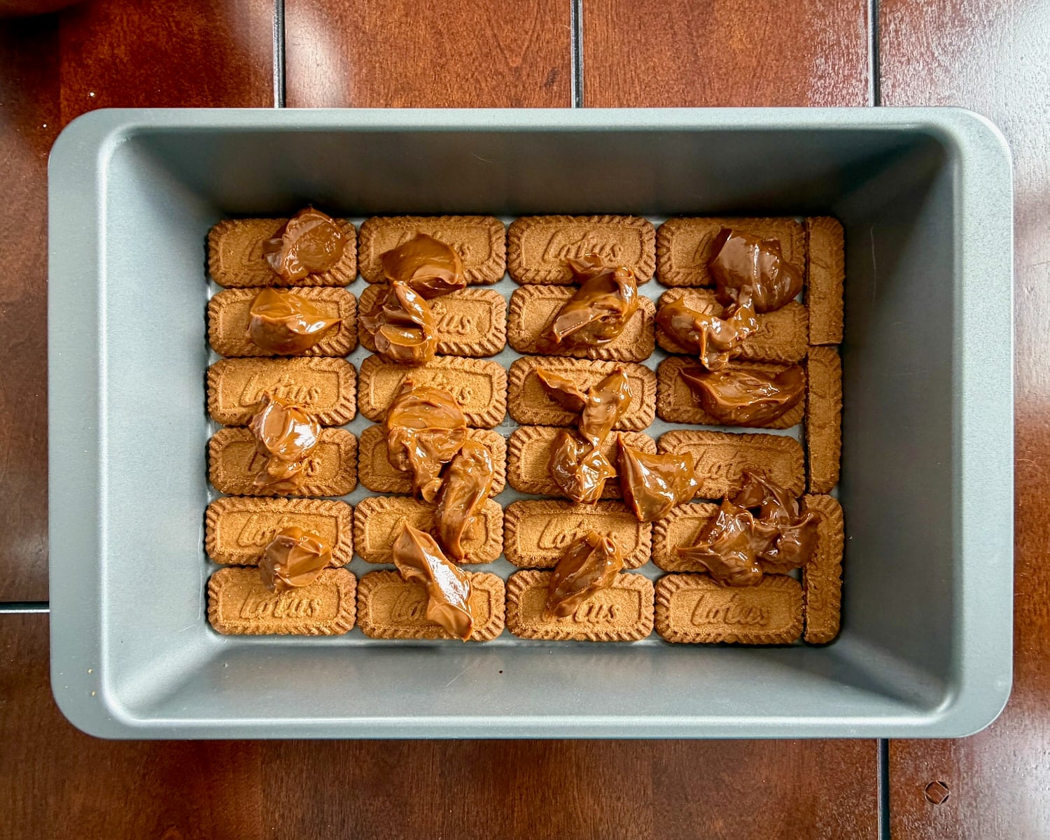 Add 1/4 of the butterscotch dulce de leche dotted over the first layer of cookies..