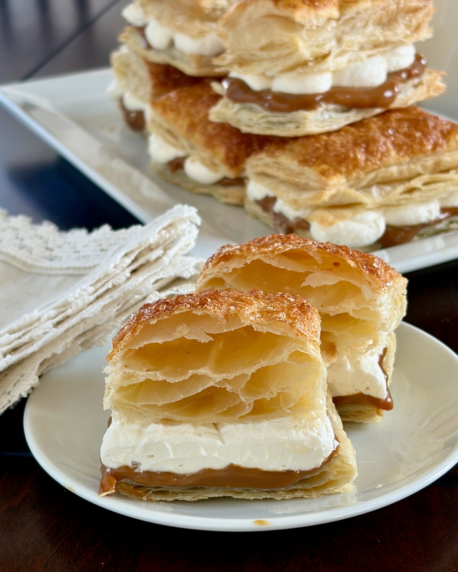 Photo of Dulce de Leche flakies with one cut in half to show the puffed pastry layers.