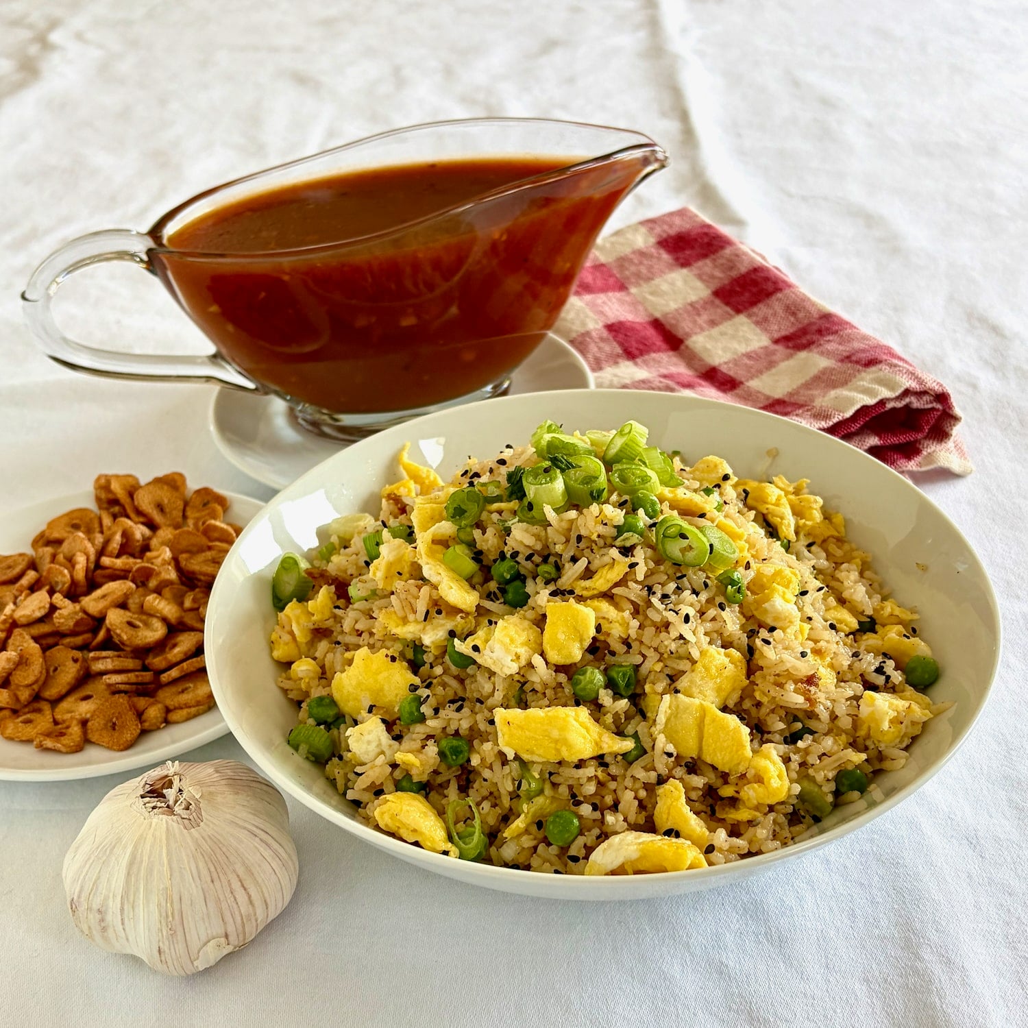 photo of a bowl of Egg Fried Rice with sweet and sour sauce and crispy garlic in the side
