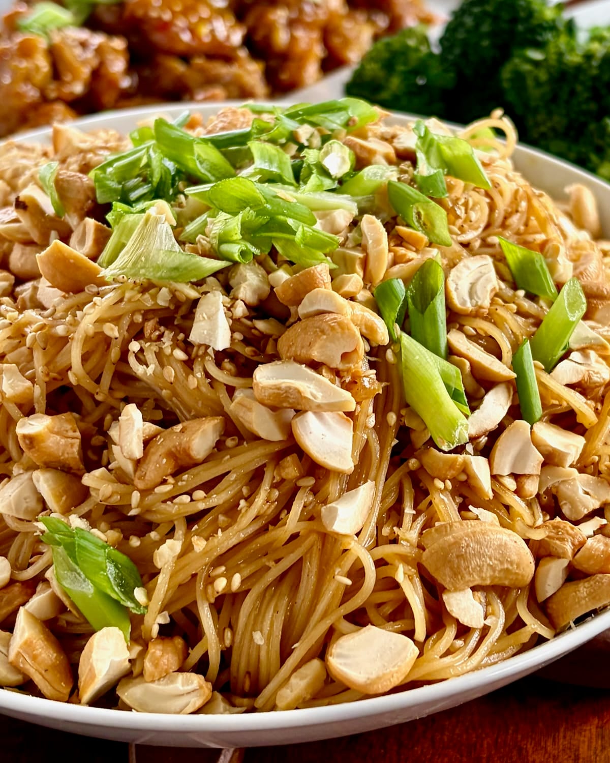 Sesame Garlic Noodles with Cashews, close up photo showing garnishes if sesame seeds and green onion.
